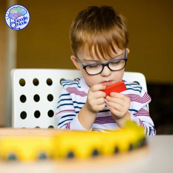 why do autistic people like trains- image of a child playing with a train set